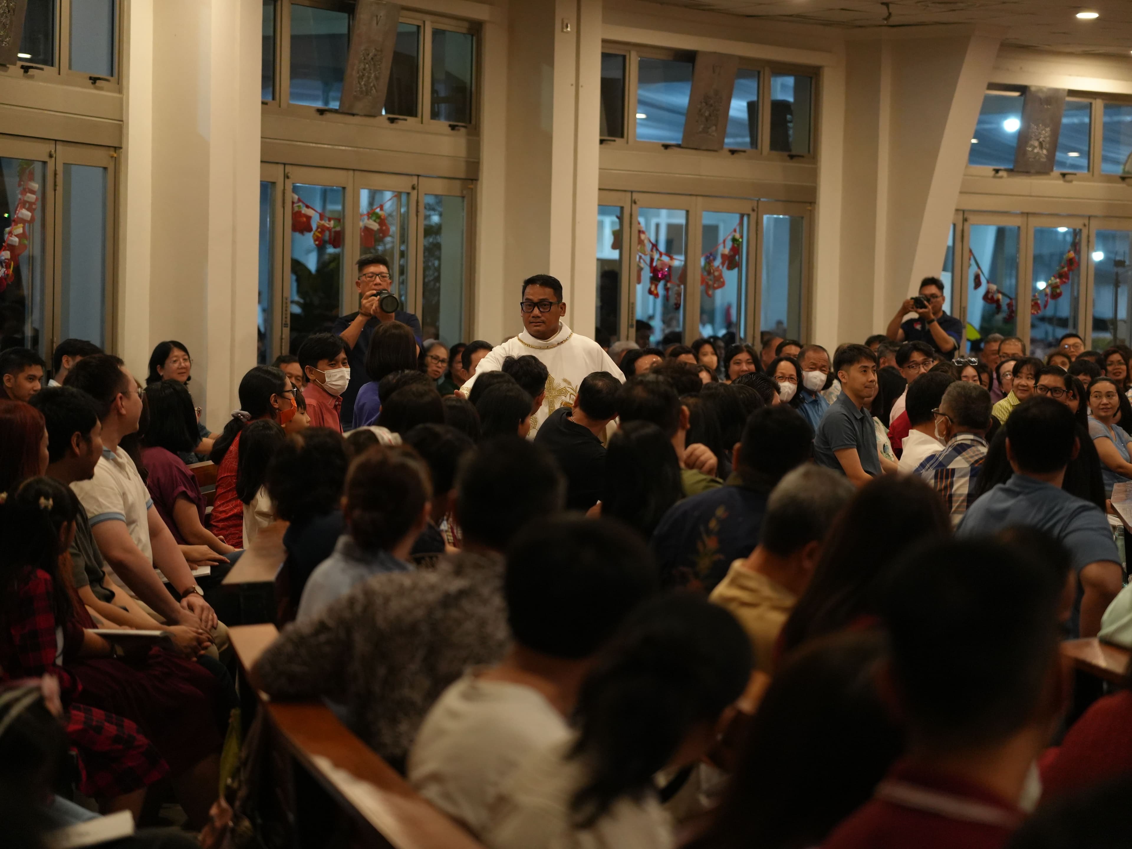 Romo membagikan hadiah di tengah-tengah umat. (KOMSOS / Bernardus Galuh)